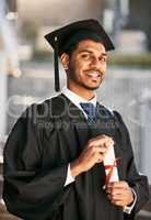 Its the biggest reward after years of hard work. Portrait of a student holding his diploma on graduation day.