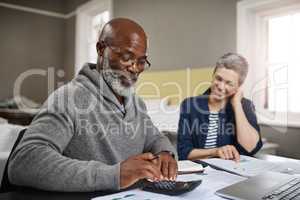 Looks like we have some extra left over. a senior couple working on their finances at home.