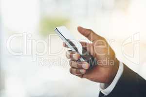 Reach out and grab success in your own hands. Closeup shot of an unrecognisable businessman using a cellphone in an office.