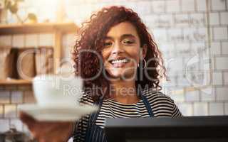 We make the best coffee in town. Portrait of a young barista holding a cup of coffee in a cafe.