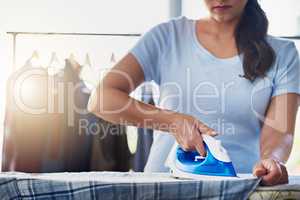 Getting straight to ironing. an unrecognizable woman doing her daily chores at home.