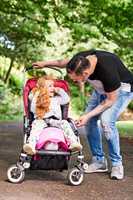 They enjoy many adventure when out on their stroll. a father pushing his little daughter in a stroller outdoors.