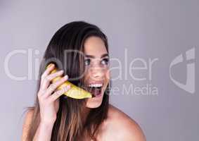 Ive got some news thatll make you go bananas. Studio shot of an attractive young woman pretending to use a banana as a phone against a purple background.