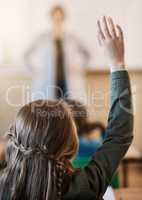 Taking part in class activities. an unrecognizable elementary school girl hand raised in the classroom.