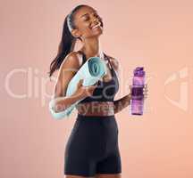 Happy, fitness and healthy while holding exercise mat and water bottle against peach studio background. Fit woman with slim body after exercise, training and sports workout and vitality healthcare