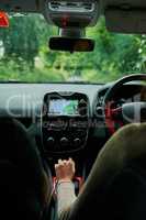 Just follow the GPS. Rearview shot of a young couple sitting in their car ready to depart on their roadtrip.