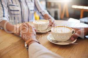 Coffee, break and dating couple holding hands on a romantic date at a cafe, restaurant or coffee shop. Man, woman or people touching, in love and romance on anniversary or valentines day together