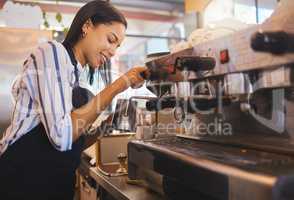 Coffee shop, cafe and restaurant with a barista working as a startup entrepreneur and small business owner. Waitress or server giving service with a smile while at work in a modern and trendy bistro