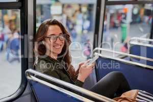 Why drive when you can take the bus. High angle portrait of an attractive young woman listening to music while sitting on a bus.