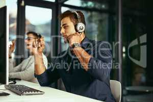 He knows how to resolve issues quickly for any client. a young call centre agent working in an office.