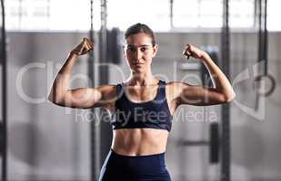 Gym, fitness and woman flexing muscles with energy to show off her biceps and strong abs in a sports studio. Training, exercise and workout motivation of a healthy, body and muscular in a portrait