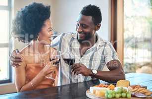 Young couple celebrating with wine and cheers at resort, laugh and bonding on romantic date. Carefree, in love black girlfriend and boyfriend toasting, enjoying relationship, alcohol and conversation