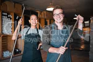 Wine making workers with press tool or equipment inside a cellar, winery or distillery warehouse with bulk quality alcohol. Woman, man or sommelier people with smile portrait for industry background