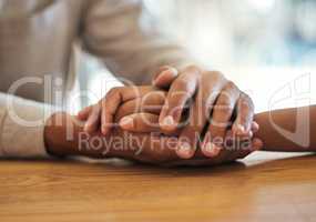 Support, unity and trust by a couple feeling grief due to cancer holding hands together on a table. Closeup of an African American man and woman bonding and connecting due to compassion and love