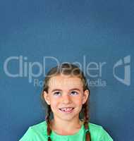 Imagination has no limit. Studio shot of an adorable little girl looking thoughtful against a blue background.