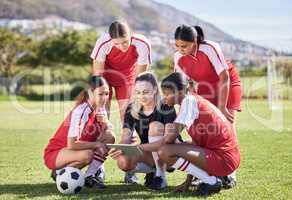 Soccer, sports and woman athlete players planning, discussing and briefing game plan by coach on digital tablet. Teamwork, training and speaking female footballers at stadium field with goal posts