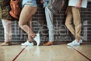 Waiting in line. a. group of unrecognizable university students standing in a campus corridor.