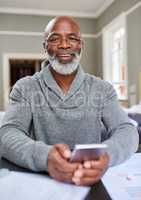 This banking app is wonderful. Cropped portrait of a senior man using his cellphone while working on his finances at home.