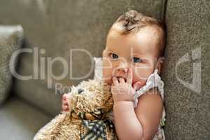 The innocence of an infant. Portrait of an adorable baby girl playing with a teddybear at home.