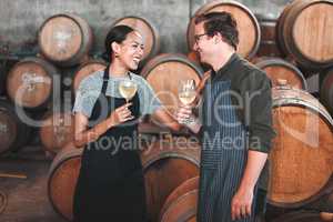 Winemaker business partners having fun talking at winery, white wine tasting and laugh. Young sommelier testing flavor and alcohol drink blend, bonding in cellar, celebrating good quality Chardonnay