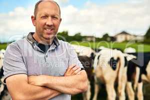 My cows are strictly free range. Cropped portrait of a male farmer standing with his arms folded on his dairy farm.