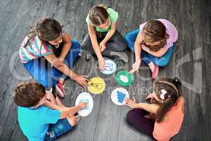 Learn and play everyday. High angle shot of a group of kids playing a game together on the floor.
