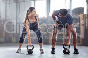 Strong, wellness couple doing kettlebell weight exercise, workout or training inside a gym. Happy sports people or trainer motivation, exercising with fitness equipment for muscle, strength or health
