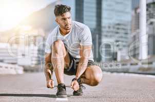 Tie shoes, fit and healthy man ready for a run, exercise and workout or training routine in urban city. Active athletic male living a health, wellness and body or weight watching fitness lifestyle