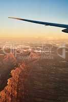 High above the mountains. High angle shot of the views from an airplane window.