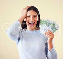 Woman celebrating success, winning money or lottery victory, holding cash or banknotes in hand. Portrait of excited, happy and proud winner screaming and laughing, with yellow copyspace background.