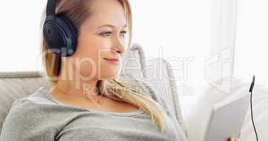 The music always helps her to relax and unwind. an attractive young woman listening to music with headphones at home.