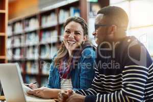 Finals will be a breeze. two university students working together on a laptop at campus.