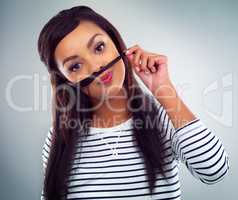 She wants to take part in Movember. a young woman posing against a grey background.