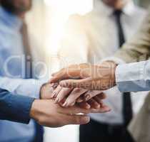 We succeed because we believe we will. a group of businesspeople putting their hands together in unity.