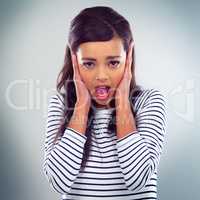 No I dont want to hear. a young woman posing against a grey background.