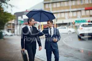 Nothing can dampen their determination to make it big. two corporate businessmen travelling through the city on a rainy day.