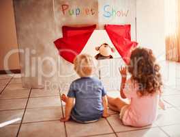 Ready for a magical puppet show. two little siblings watching a puppet show at home.