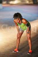 Keep on challenging yourself. a sporty young woman taking a break while out for a run.