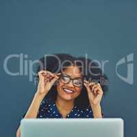 Time to take a peek inside the world wide web. Studio shot of a young woman using a laptop against a gray background.