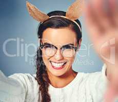 These rabbit ears are putting me in such a mood. Studio shot of a young woman wearing costume rabbit ears against a plain background.