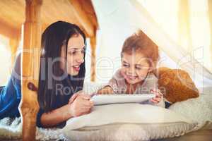 Becoming a connected family. a mother and her little daughter using a digital tablet together at home.