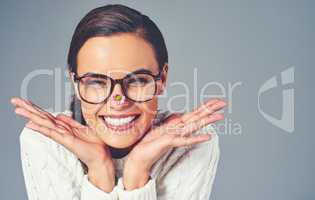 Personality is what captures the heart. Studio shot of a young woman with a flower on the tip of her nose.