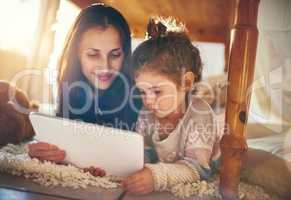 Exploring the digital world. a mother and her little daughter using a digital tablet together at home.