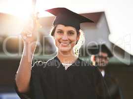 Its official Im qualified. Portrait of a happy young woman holding a diploma on graduation day.