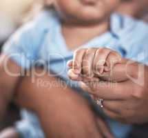 Tiny hands that bring great love. Closeup shot of a mother holding her baby boys hands at home.