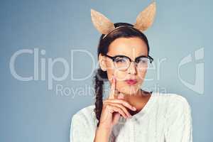 Maybe I like being silly, consider that. Studio shot of a young woman wearing costume rabbit ears against a plain background.