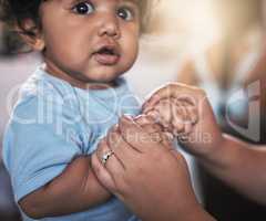 Completely cute and carefree. Portrait of an adorable baby boy playing with his mother at home.