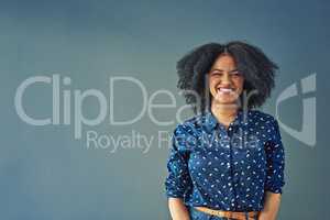 Choose the things that make you smile. Studio shot of a happy young woman posing against a gray background.