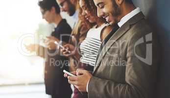 Connect with other businesses in your industry. businesspeople using their cellphones while standing in a row.
