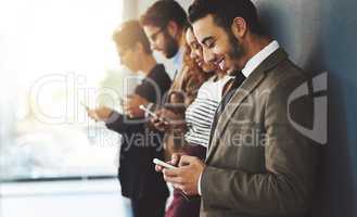 Join by simply signing up and then creating a profile. businesspeople using their cellphones while standing in a row.
